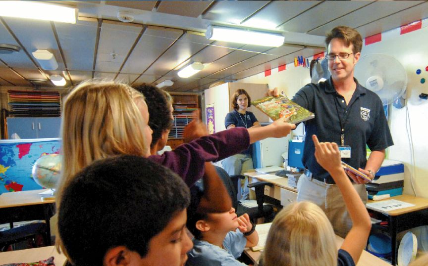 Brian Blackburn, of Mercy Ships, handing books to children.