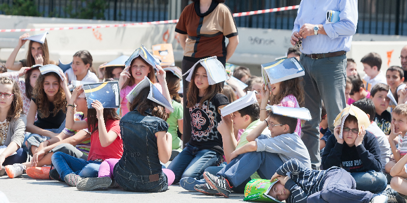 Kids putting books over their heads