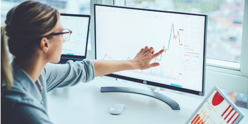 A school business manager reviewing a report displayed on a computer screen