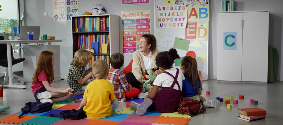 Children and caretaker sitting on the floor at a childcare center