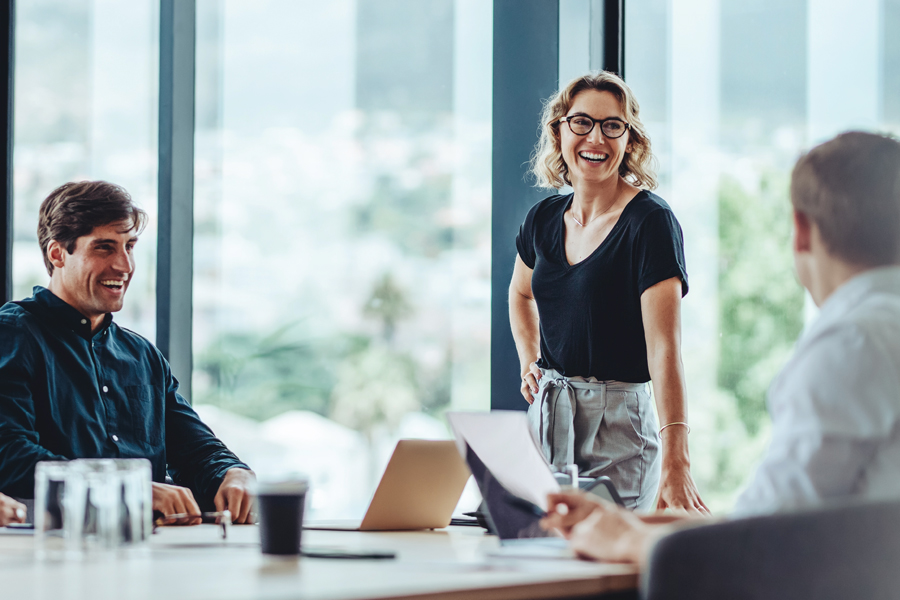 Three colleagues smiling in a meeting