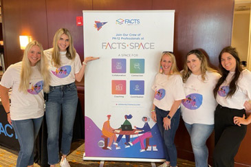FACTS Space Community team posing in front of a display banner
