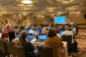Attendees at a FACTS Elevate 2022 training session with their laptops