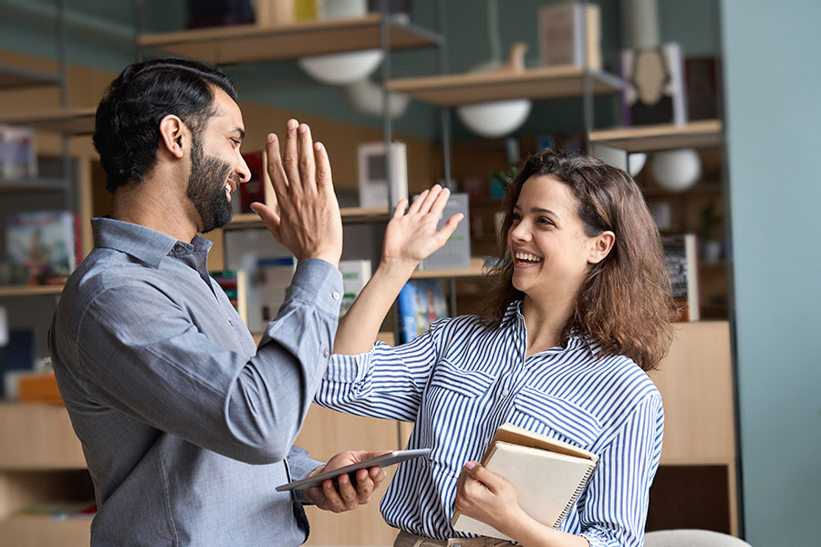 Two happy coworkers high-fiving each other