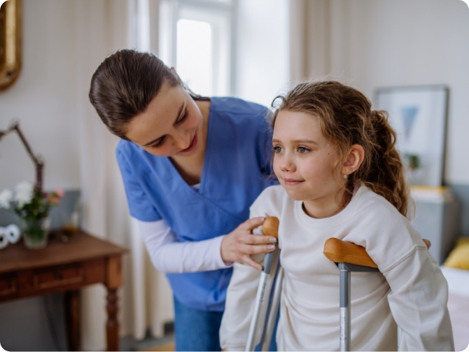 Young child on crutches being assisted by a nurse